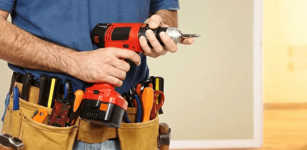 Handyman holding a power drill for home repairs and installations in Seattle, WA