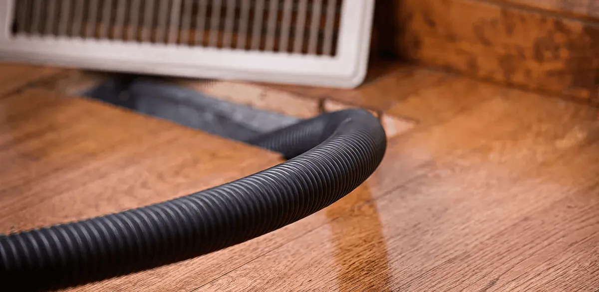 Air duct cleaning hose inserted into a floor vent for ductwork cleaning in Seattle, WA