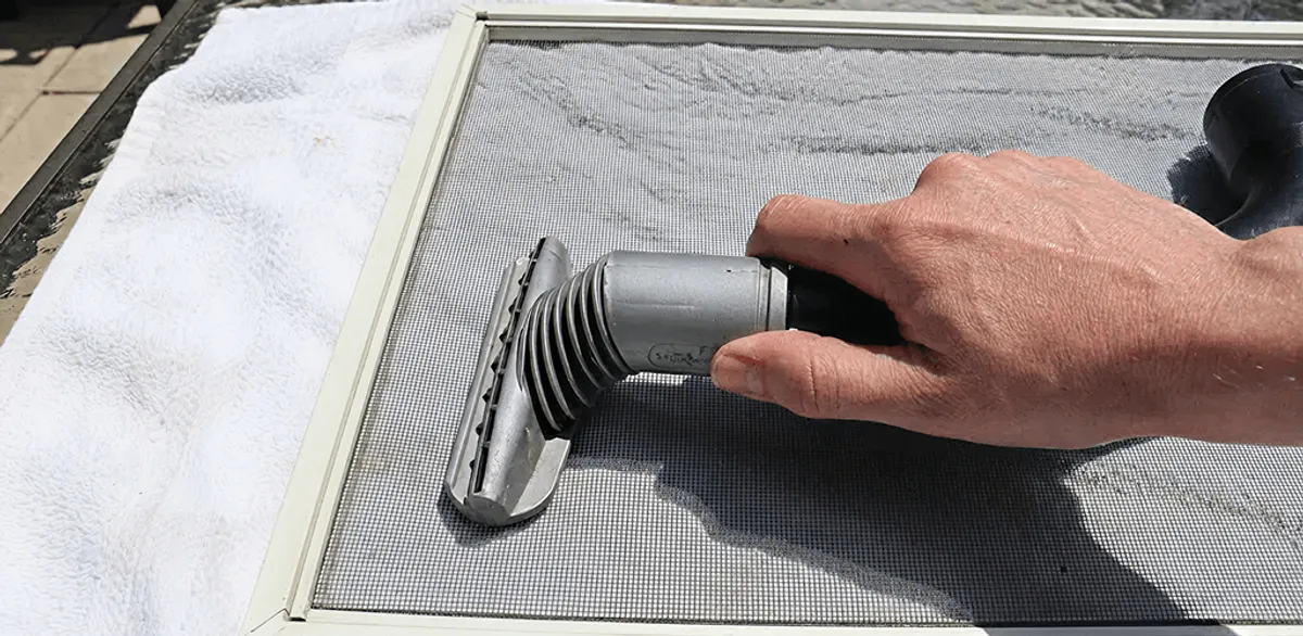 Window screen repair cleaning and fixing a damaged screen mesh in Seattle, WA